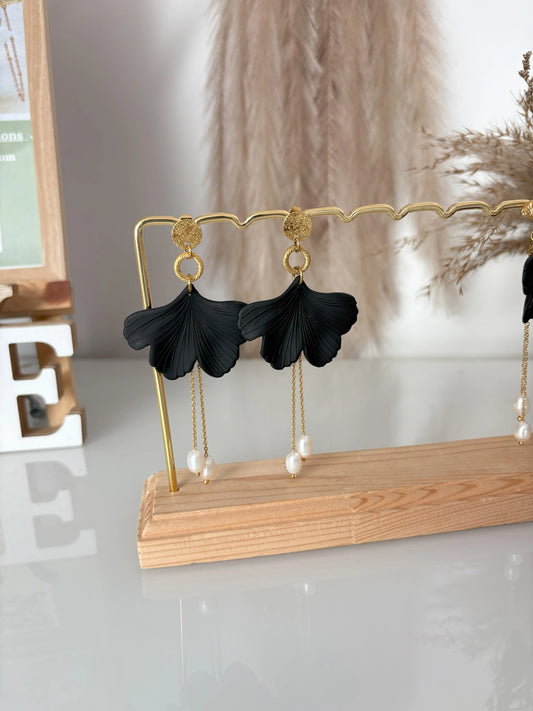 Boucles d'oreilles clous à disque martelé avec pendentif gecko noire ornées d'une double chaînette pendantes avec des perles d'eau douce suspendues. Bijou en acier inoxydable doré présenté sur une barre métallique dorée.