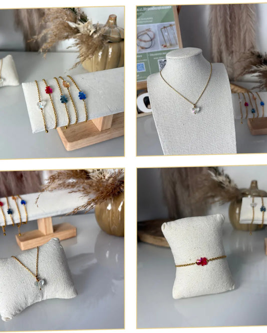 grille composée de 4 photos présentant des bijoux présentés sur présentoirs. Bracelets chaîne en acier inoxydable doré, ornés d'une perle ours colorée ou perle papillon en cristal. Collier chaîne en acier inoxydable dorée et ornée d'une perle papillon en cristal.