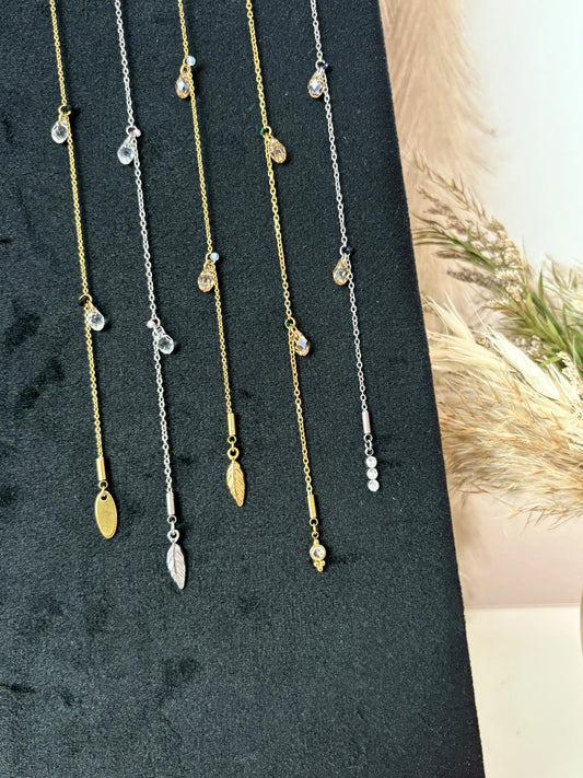 bijou pour cheveux présentés sur un plateau en velours à la verticale. Bijoux en acier inoxydable doré et argenté avec des perles goutte en cristal beige et transparente.