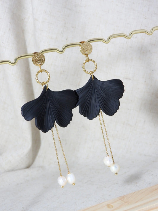 Boucles d'oreilles clous à disque martelé avec pendentif gecko noire ornées d'une double chaînette pendantes avec des perles d'eau douce suspendues. Bijou en acier inoxydable doré présenté sur une barre métallique dorée.
