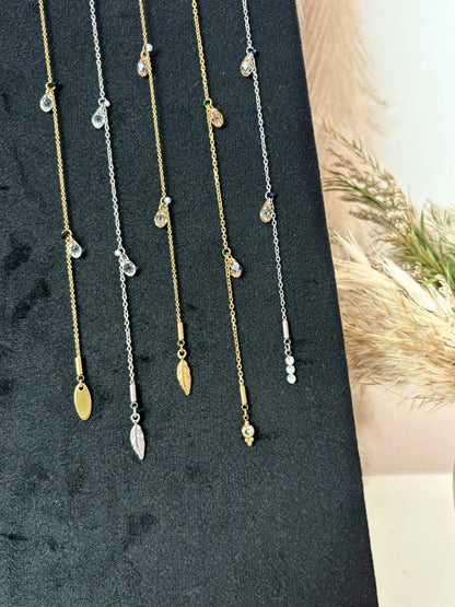 bijou pour cheveux présentés sur un plateau en velours à la verticale. Bijoux en acier inoxydable doré et argenté avec des perles goutte en cristal beige et transparente. 