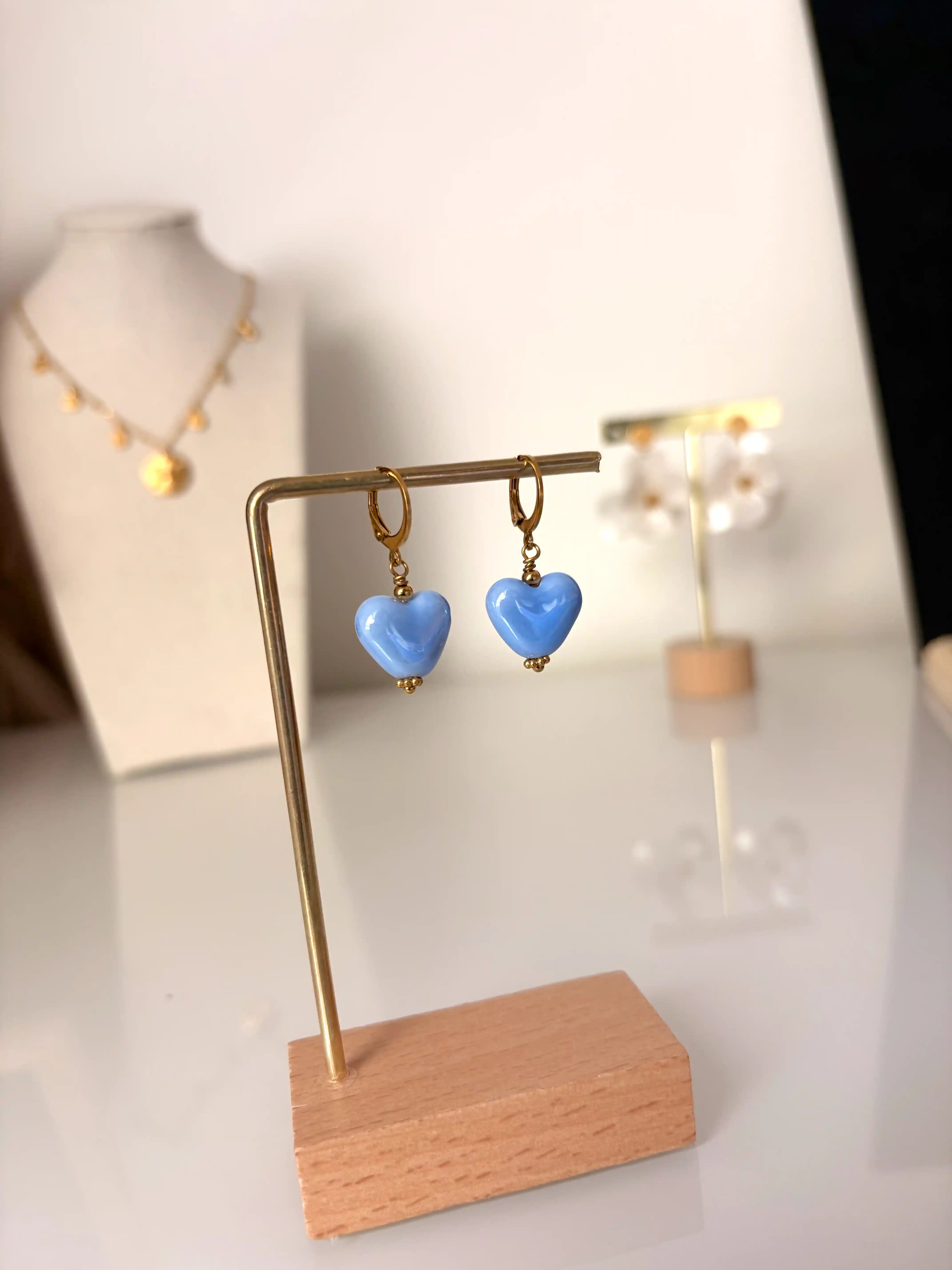 Boucles d'oreilles mini-créoles en acier inoxydable doré et ornées d'une perle céramique coeur bleu