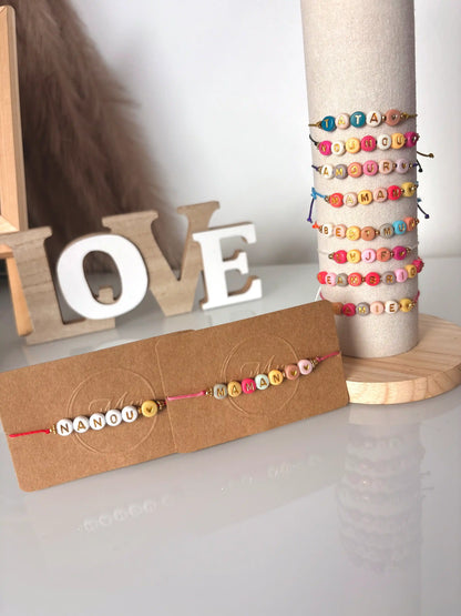 bracelets cordon à perles colorées formant un message à personnaliser. Bijoux présentés sur carton kraft et tube vertical.