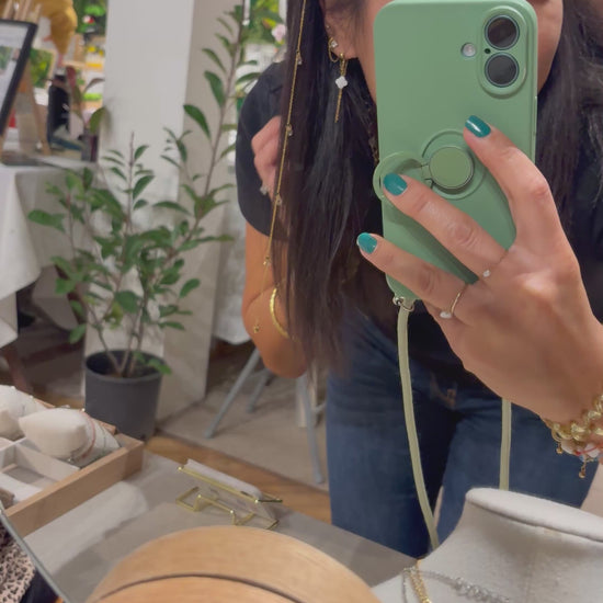 vidéo présentant le créatrice de bijoux de la marque M'Joy Creation qui porte un bijou pour les cheveux, composé d'une barrette noire associée à une chaîne en acier inoxydable doré et orné de perles goutte en cristal beige. 
